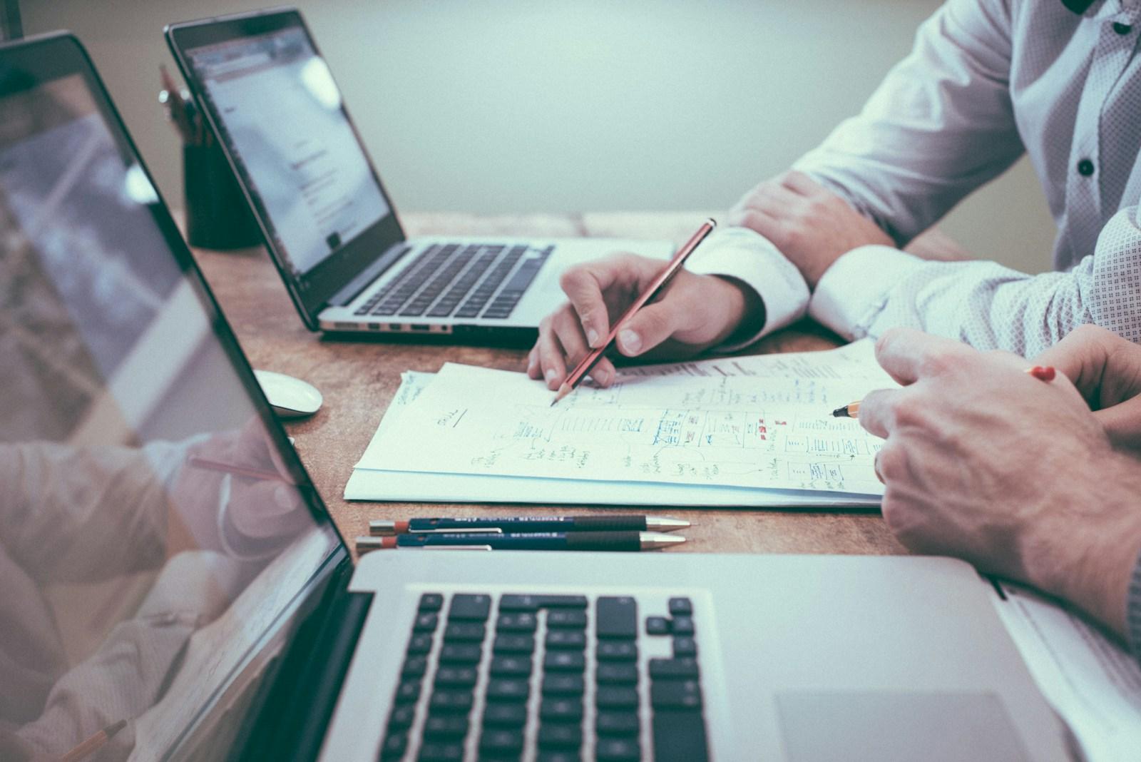 Colleagues reviewing notes and financial charts at a work table